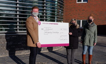 Lars Weber, links im Bild, überreicht 1.000 Euro als Weihnachtsspende an Inka Ovens (Mitte) und Daniela Urbiks vom Stadtjugendring Schneverdingen e. V.