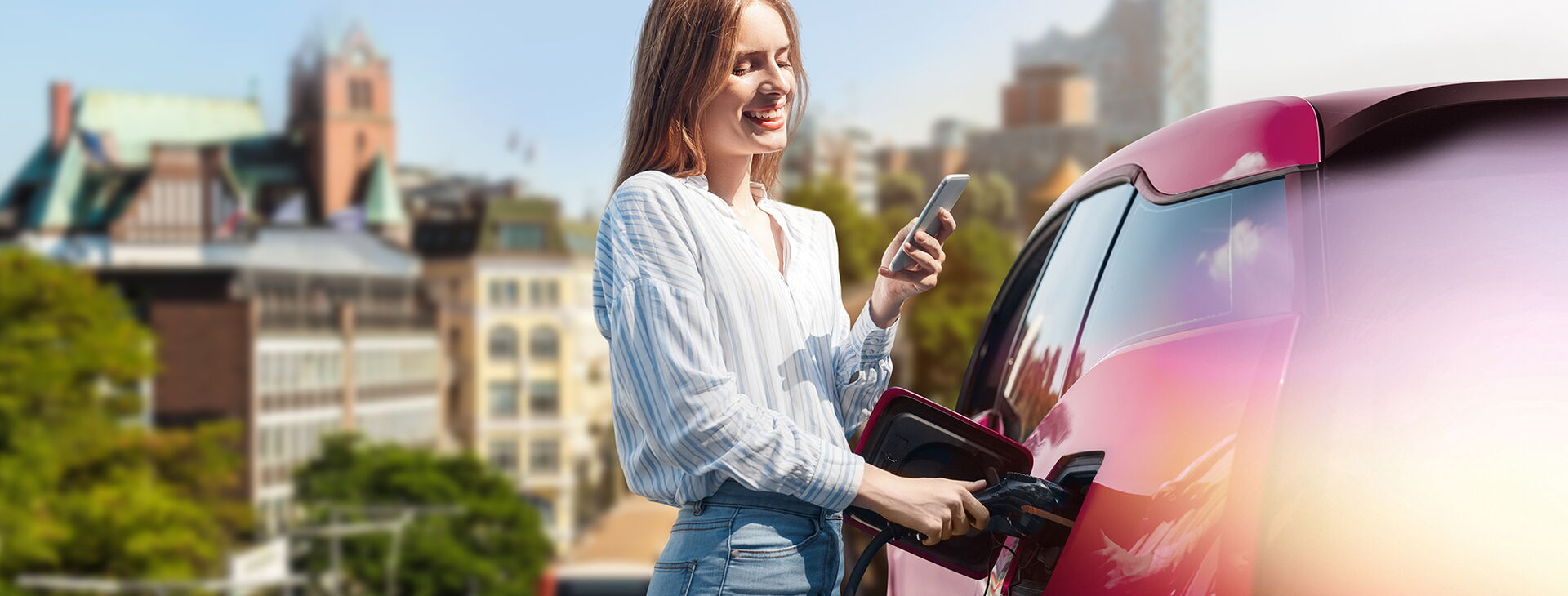Lachende Frau tankt ihr Elektrofahrzeug