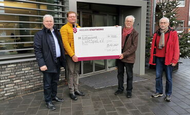 Lars Weber und Stefan Lamping übergeben einen Spendenscheck in Höhe von 1000 Euro an Wolfgang Mader und Wolfgang Voigt vom LichtSpiel e.V. Schneverdingen.