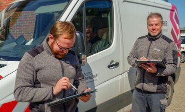 Die Strom-Monteure Denis Klemm und Bernd Schröder dokumentieren das Tagwerk auf dem Betriebshof per Tablet über das firmeneigene WLAN.
