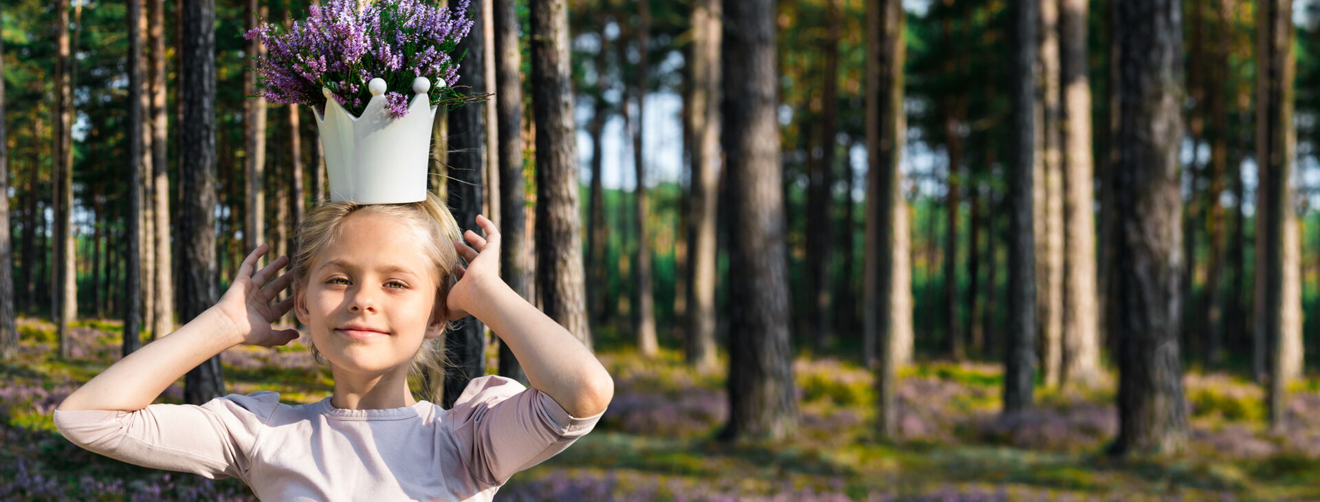 Ein Mädchen im Wald mit einer Krone auf dem Kopf