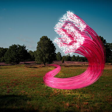 Mehrere pinke Kabel laufen über eine Wiese und bilden an deren Enden das Logo der Heidjers Stadtwerke