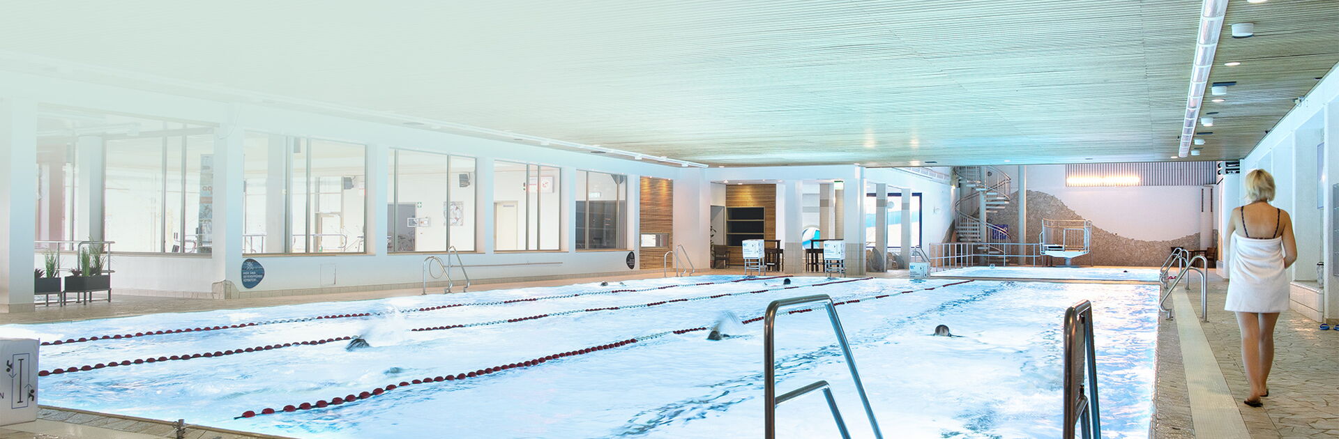 Ein großes Schwimmbecken im Heidjers Wohl in dem einige Personen schwimmen