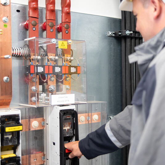 Elektriker überprüft eine Maschine die an der Wand hängt
