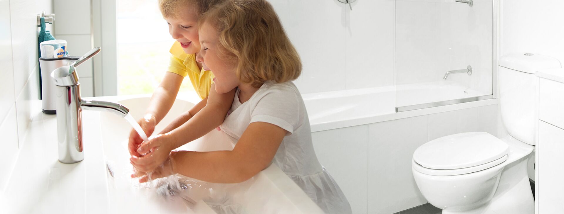Zwei Kinder waschen sich an einem Waschbecken in einem Badezimmerdie Hände