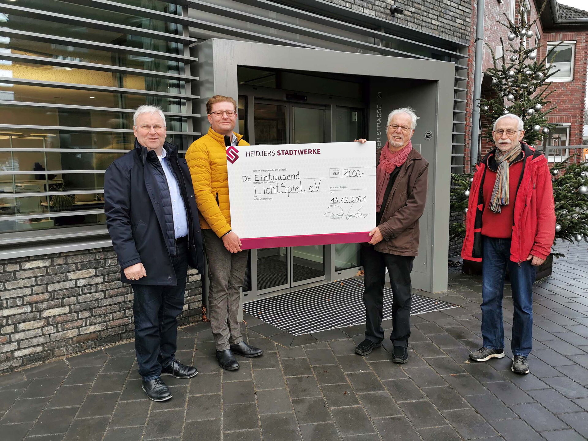 Lars Weber und Stefan Lamping übergeben einen Spendenscheck in Höhe von 1000 Euro an Wolfgang Mader und Wolfgang Voigt vom LichtSpiel e.V. Schneverdingen.