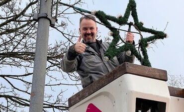 Monteur Jörg Tilgert installiert einen der 111 Sterne, die das Stadtgebiet in der Adventszeit in warmes Licht tauchen.