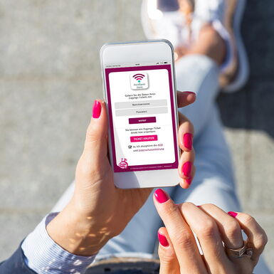 Eine Frau die ein Smartphone in der Hand hält auf dem die App der Heidjers Stadtwerke geöffnet ist