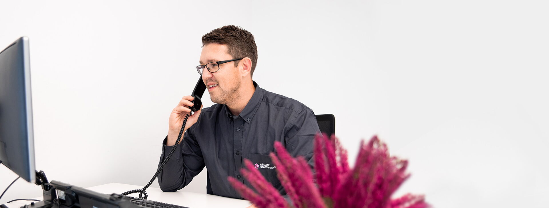 Mitarbeiter Stefan Willner sitzt am Computer und beantwortet am Telefon die Fragen der Kunden