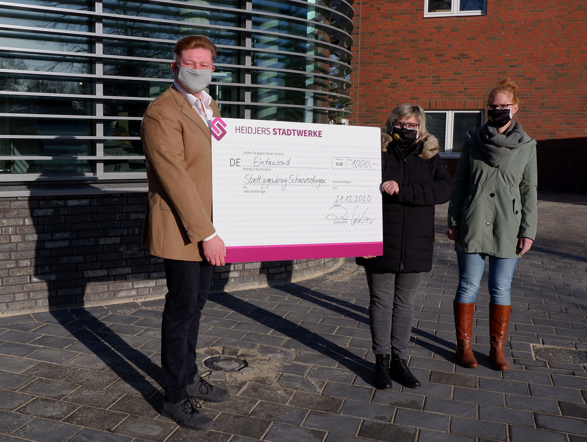 Lars Weber, links im Bild, überreicht 1.000 Euro als Weihnachtsspende an Inka Ovens (Mitte) und Daniela Urbiks vom Stadtjugendring Schneverdingen e. V.