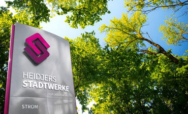 Das Logo der Stadtwerke Schneverdingen auf einer flachen Säule draußen