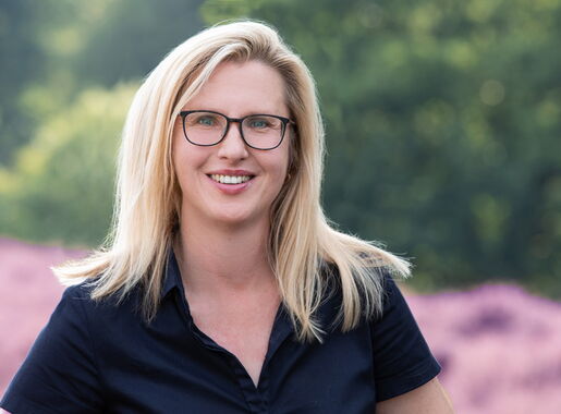 Mitarbeiterin Katja Göricke vor einer Heidelandschaft