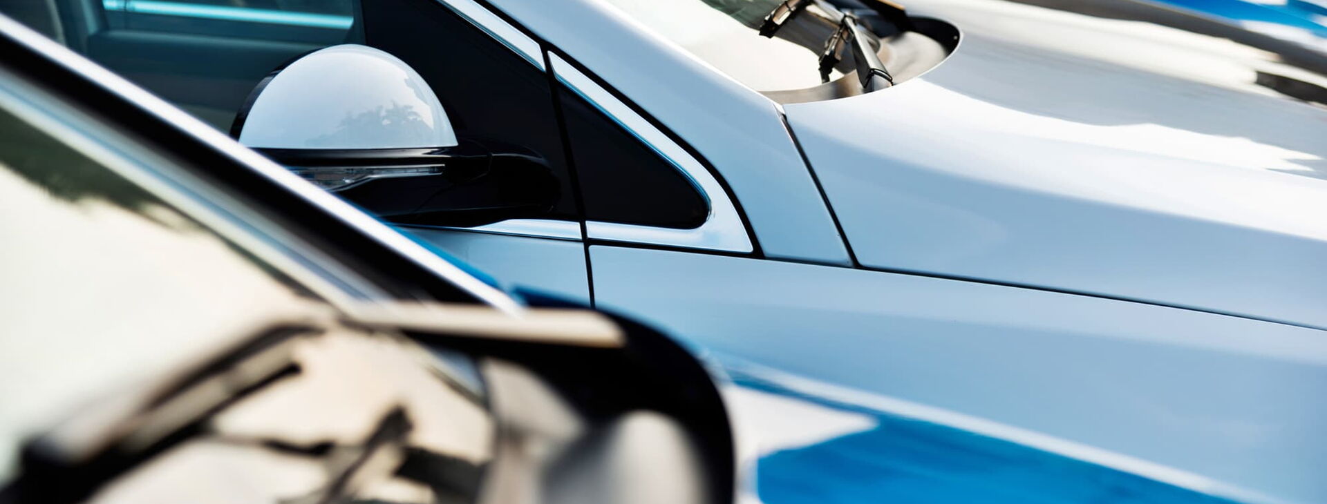 Autos stehen in einer Reihe, im Fokus ist die Fronthaube